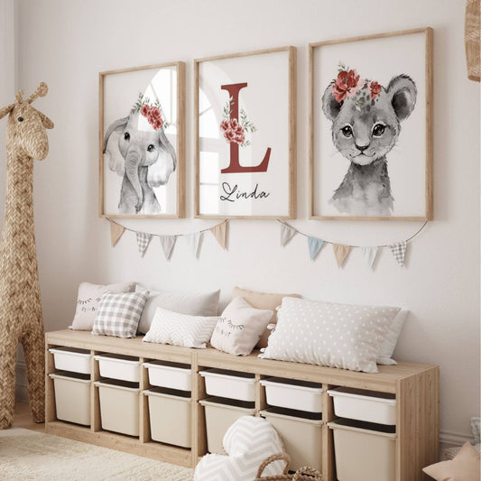 Décoration murale chambre bébé avec une toile éléphant, une toile lionceau et une toile initiale et prénom. Les animaux porte une couronne de fleur sur le coté couleur rouge foncé